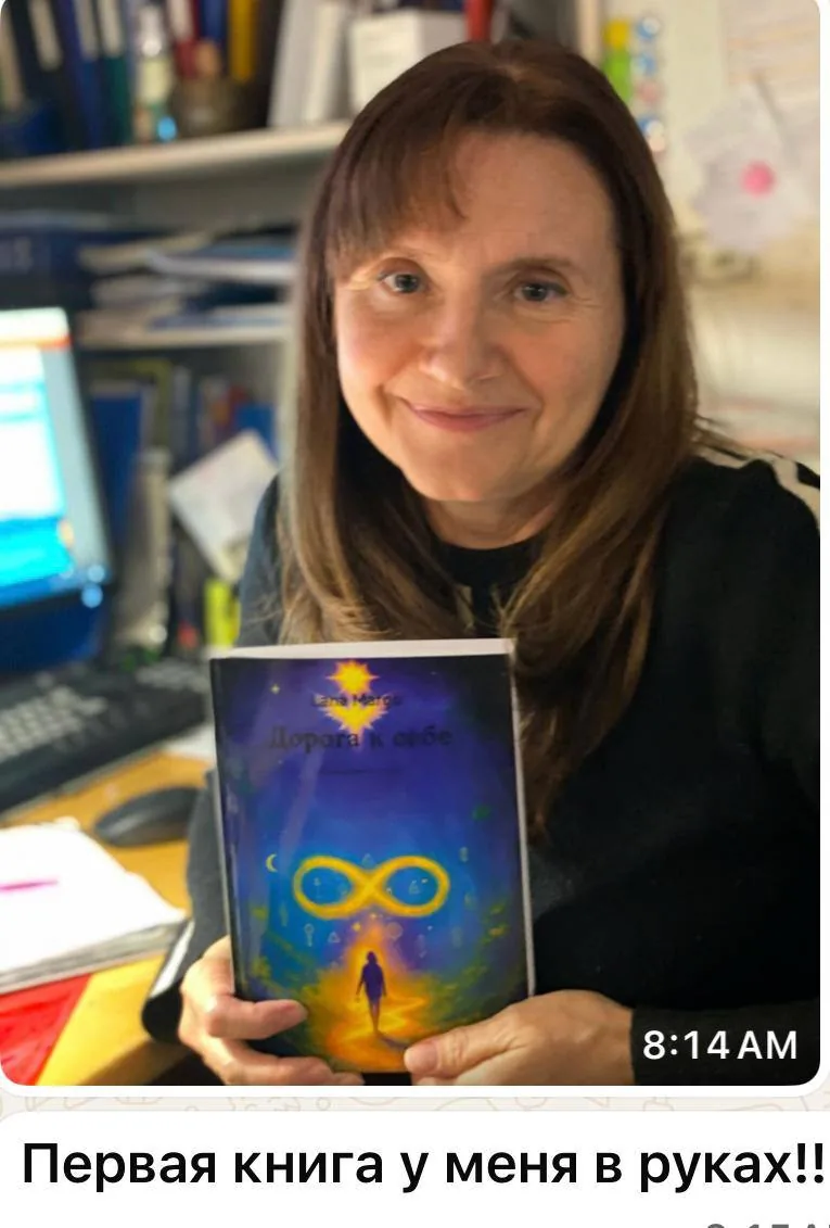 Улыбающаяся женщина держит в руках книгу с сияющей обложкой и символом бесконечности на пути к мечте