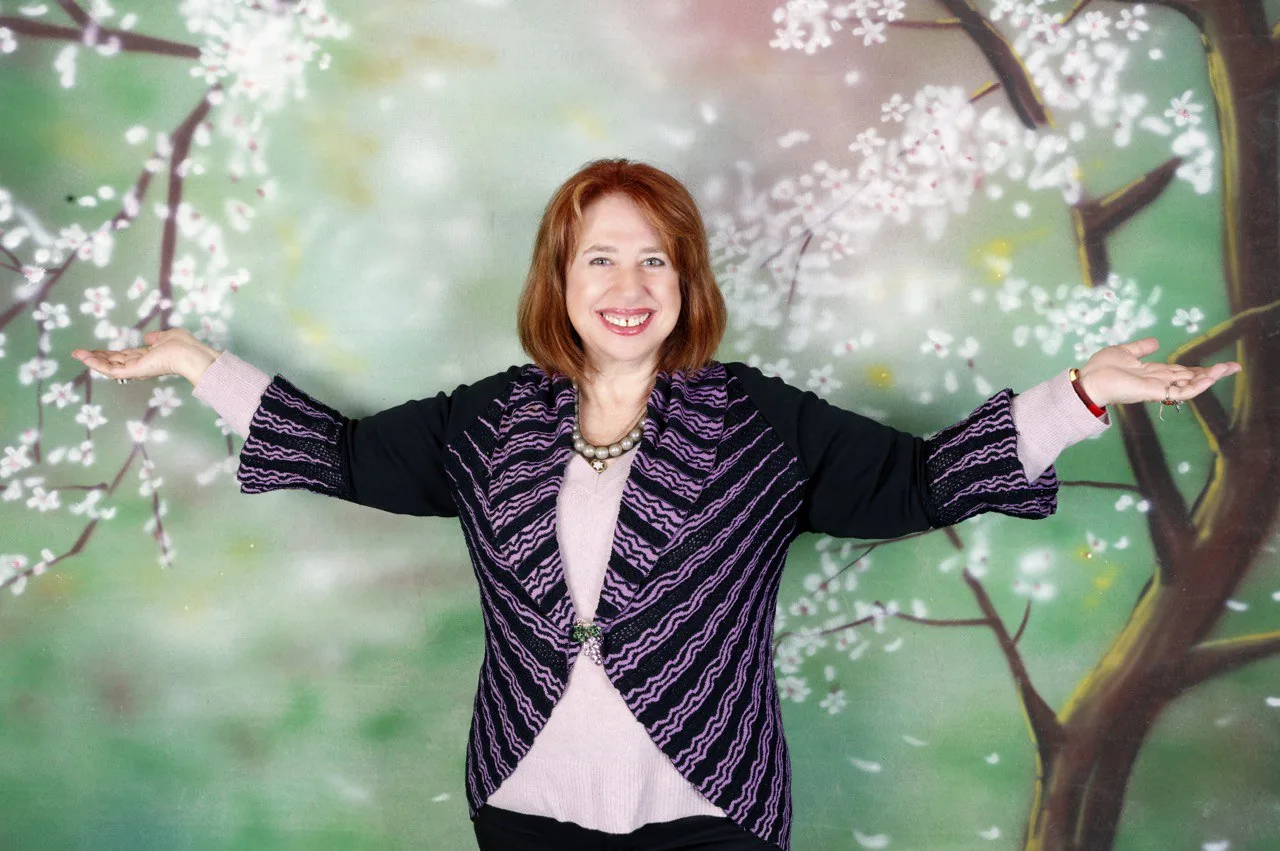Женщина с рыжими волосами с раскинутыми руками на фоне цветочного узора, образ ищущей свой путь в эмиграции